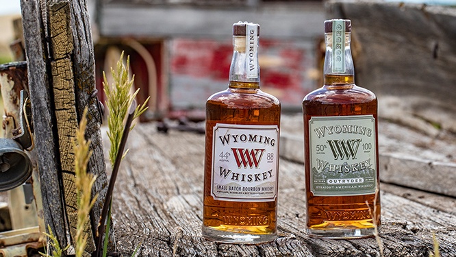 two bottles of wyoming whiskey on a wooden truckbed