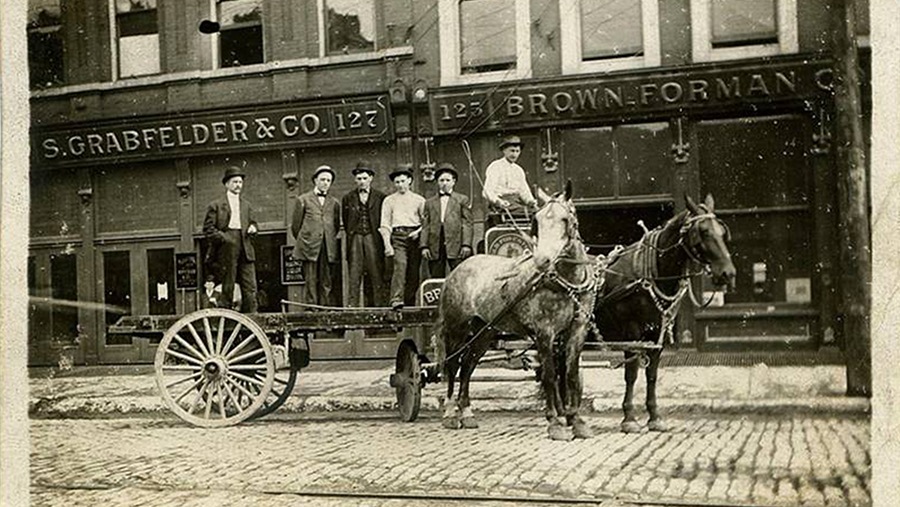 men standing on horse-drawn buggy on cobblestone street