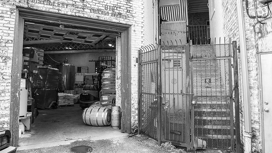 outside view of open loading dock doorway revealing warehouse contents besides metal gating