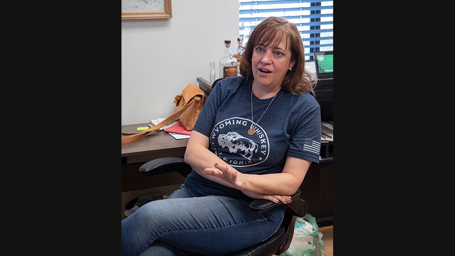 Operational manager Blair Woodall, a fair skin woman with brown hair wearing a navy t-shirt, sitting in a chair and talking to someone out of view
