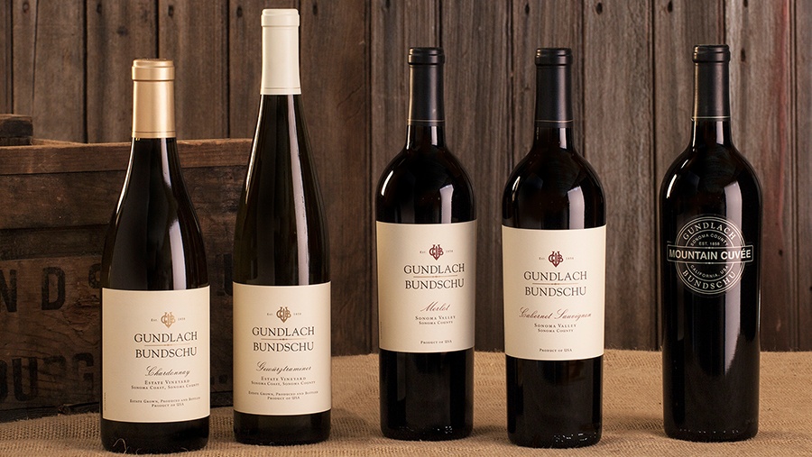 Five bottles of Gundlach Bundschu estate wines lined up side by side on burlap