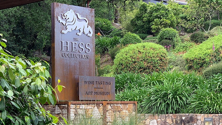 metal entrance sign bearing the hess family lion crest at the hess collection vineyard