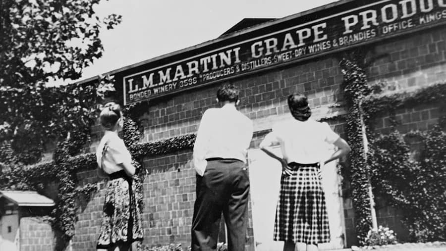 vintage photo of a man and two women outside the L.M. Martini Grape Products company in 1922