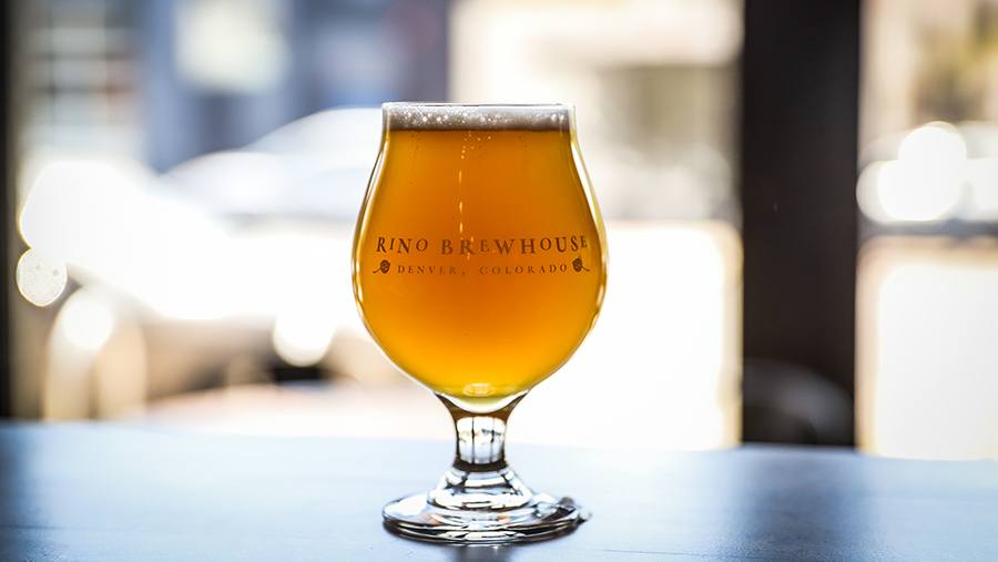glass snifter filled with Odell beer sits atop a table