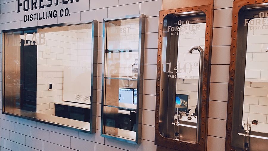 windows in a wall showing a lab and pipes used to pour high-proof alcohol into a sealed chamber