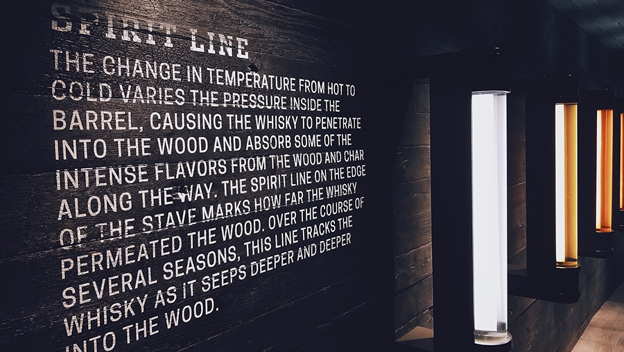 educational description on a black wooden wall explaining whisky barrel aging effects