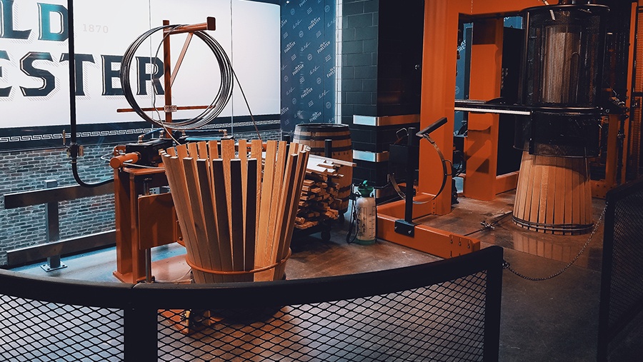wooden staves sit inside a contraption that assists in the assembly of whisky barrels