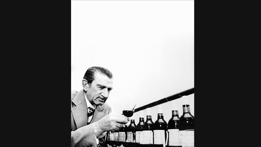 Penfold's original Chief Winemaker, Max Schubert, visually inspects wine quality from a row of snifters filled from a variety of bottles