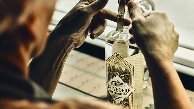 A man putting the finishing touches on a bottle of Belvedere Vodka