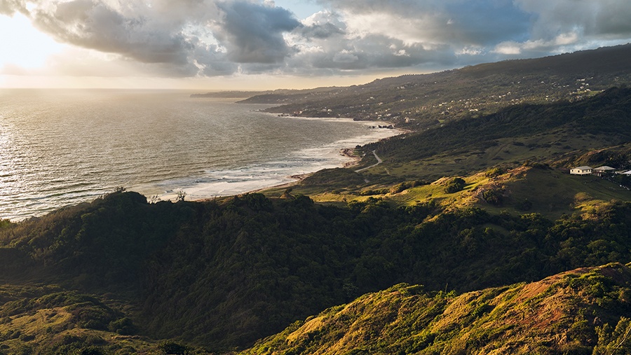 Coastal view of Barbados’ green hilly fields during a sunset